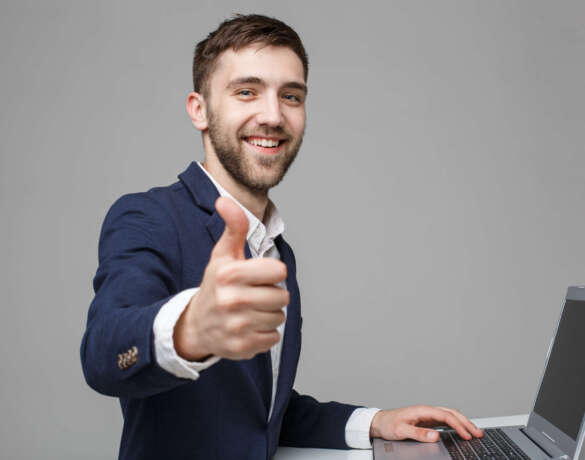 Business Concept - Portrait Handsome Business man showing thump up and smiling confident face in front of his laptop. White Background.Copy Space. Business Concept - Portrait Handsome Business man showing thump up and smiling confident face in front of his laptop. White Background.Copy Space.